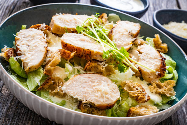 istock Caesar salad  - vegetable salad with roast chicken breast on wooden table 1497943533