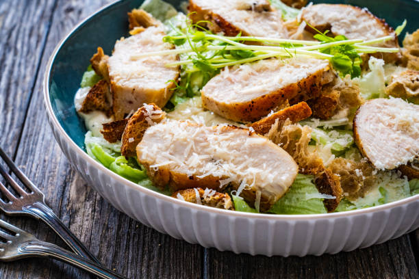 istock Caesar salad  - vegetable salad with roast chicken breast on wooden table 1497943554
