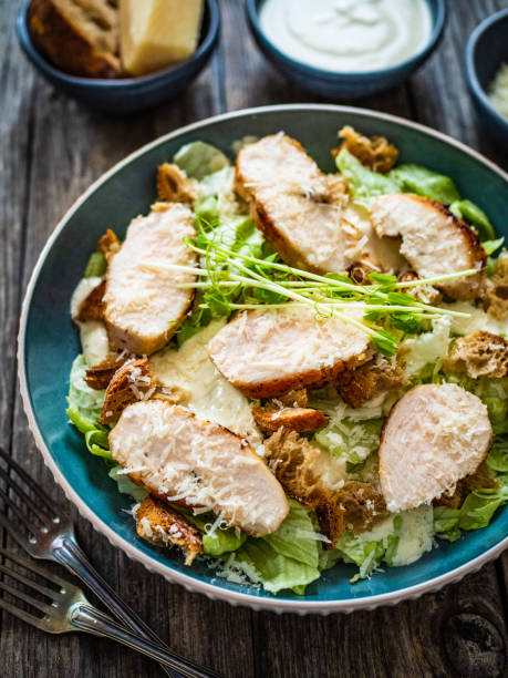 istock Caesar salad  - vegetable salad with roast chicken breast on wooden table 1497943612