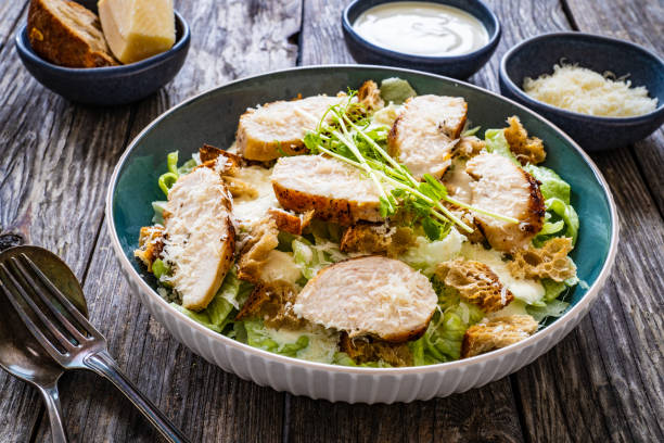 istock Caesar salad  - vegetable salad with roast chicken breast on wooden table 1497943641