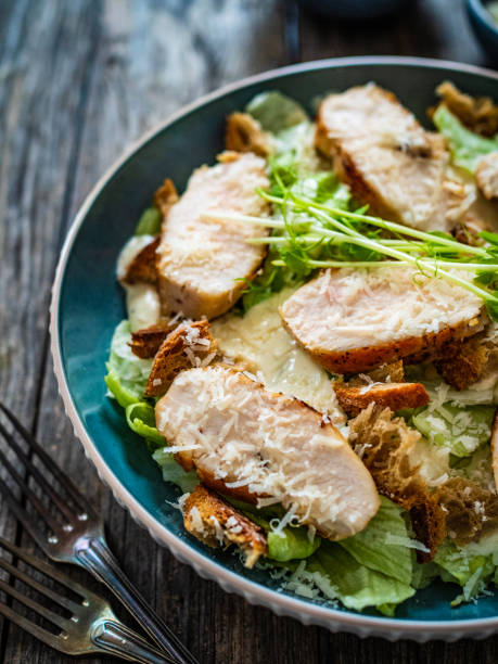 istock Caesar salad  - vegetable salad with roast chicken breast on wooden table 1497943714