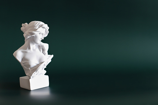 Marble head of young woman, ancient Greek goddess bust on green background with space for text