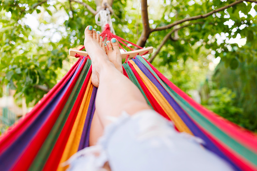 Woman relaxing in a hammock in a summer garden.