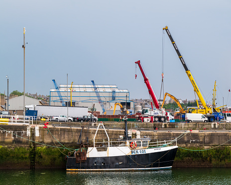 12 June 2023. Buckie,Moray,Scotland. This is a view of the daily workings within Buckie Harbour, Fishing Boat, Cranes offloading Boats with windfarm parts and cereal.