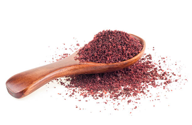 istock Ground sumac spice pile in wooden spoon isolated on a white background 1497955267