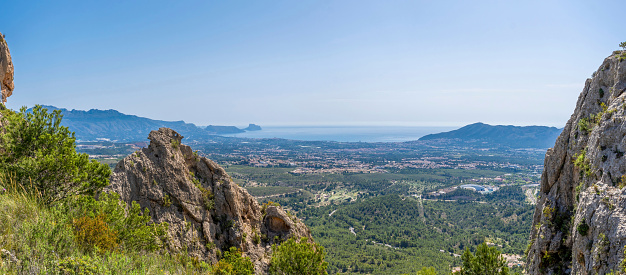 Panoramic of the Mediterranean coast between mountains, Benidorm and the Peñon de Ifach in the background. In Alicante, Valencian Community, Spain