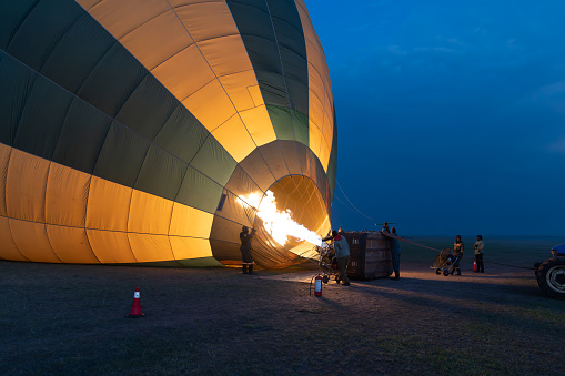 Kenya, Africa - March 10, 2023: Crew prepares and inflates a hot air balloon for a safari over the Masaai Mara Reserve for tourists