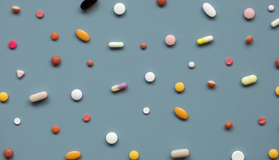 Top view of various pills on the blue background.