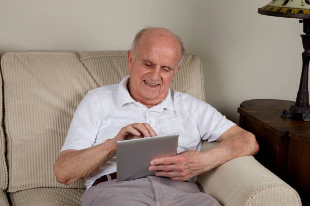 istock Senior man at home enjoying digital tablet 1497964191
