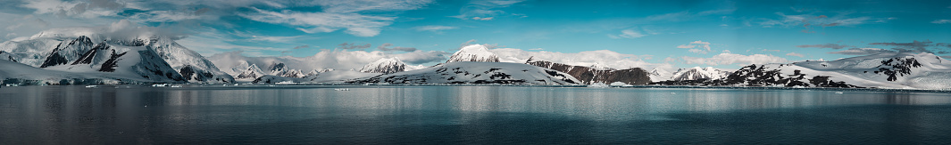 A panorama of snowy clad mountains in the Antarctic Peninsula.