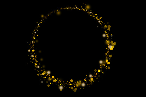 Round frame of gold sparkles and glitter on black background. Abstract defocused lights and bokeh on dark background