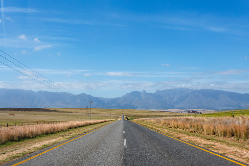 Landscape with an empty  road and a landscape with mountains in the background in Western Cape, South Africa, Africa