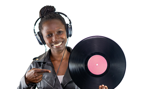 Young woman holding a vinyl while listening to music on her headphones with a white background