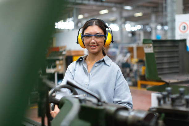 istock Female apprentice engineer working with CNC machine in factory 1497969225
