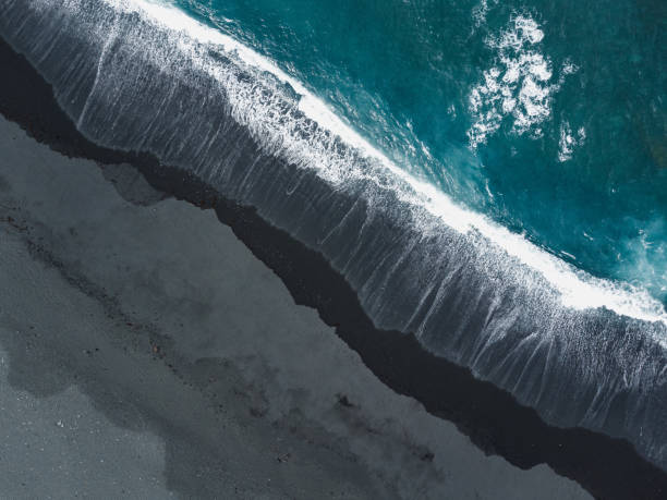 вид на черный песок и бирюзовый океан сверху - lanzarote bay canary islands beach стоковые фото и изображения