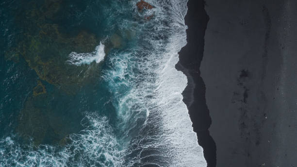 istock View on black sand and turquoise ocean with waves from above 1497971634