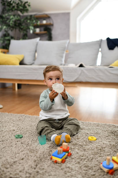 istock Baby Boy Sitting On Floor And Drinking Water 1497972598