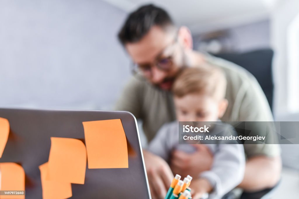 Father Putting Work First Father Completes Work Notes And Tasks While Looking After Baby Son ...