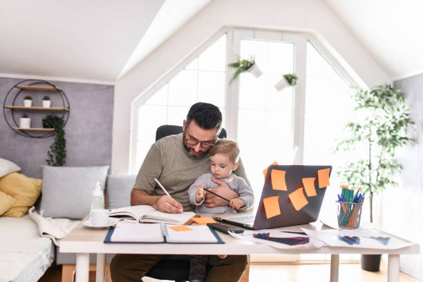 istock Father Introduces Baby Boy To Writing In Notebook 1497972703
