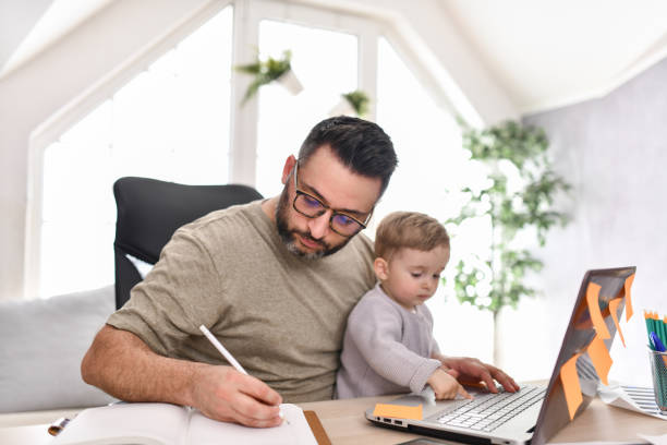 istock Freelancing Male Looking After Baby Son And Working At The Same Time 1497972807