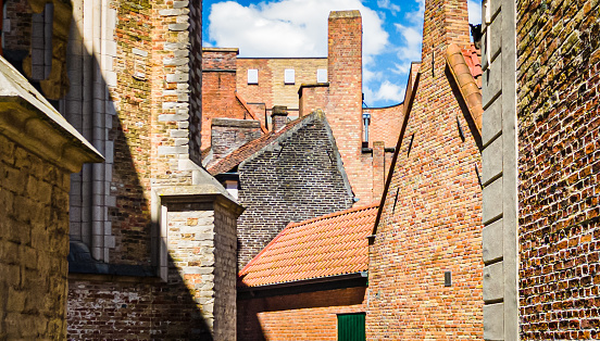 View of brick walls and tiled roofs of an array of buildings in Bruges, Belgium