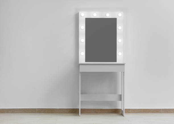 istock Modern white makeup dressing table with mirror and backlight on a white wall close-up. 1497974069
