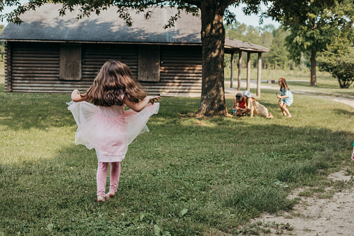 Little girl wearing tutu dances outdoors