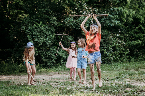 Group of elementary age girls play outdoors and enjoy childhood