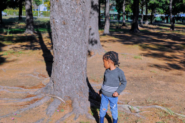 African black boy picking with flowers in a park.