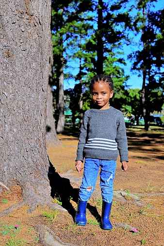 African child playing in the woods in a park