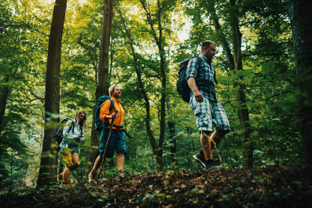 Closeup side view of group of mid 30's people hiking through a forest.