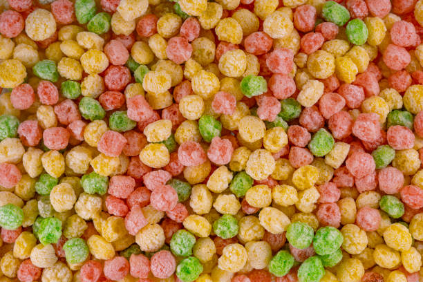 Cereal colored balls. Breakfast food. flat lay, top view. Delicious and nutritious fruit cereal loops flavorful, healthy and funny addition to kids breakfast. Cereal background. Colorful breakfast food stock photo.