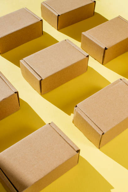 istock Many cardboard kraft boxes on a yellow background. Packing the parcel. 1497986781