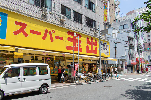 Osaka, JAPAN - May 23 2022 : Store front of Super Tamade seen in sunny day, Suomachi. Super Tamade is a Japanese discount supermarket chain known for its affordable prices on store products.