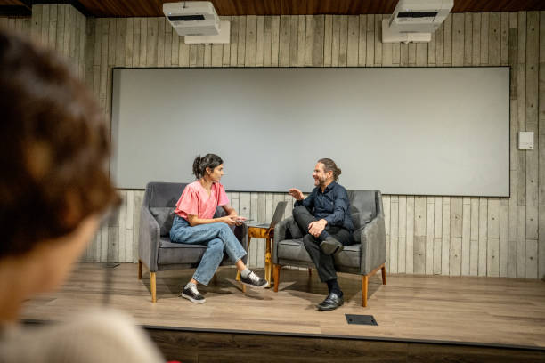 Young woman interviewing a man at studio