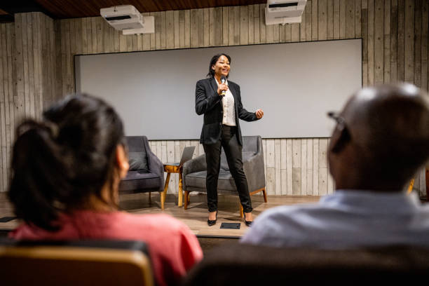 istock Mature woman talking with public on microphone in a seminar 1497998823