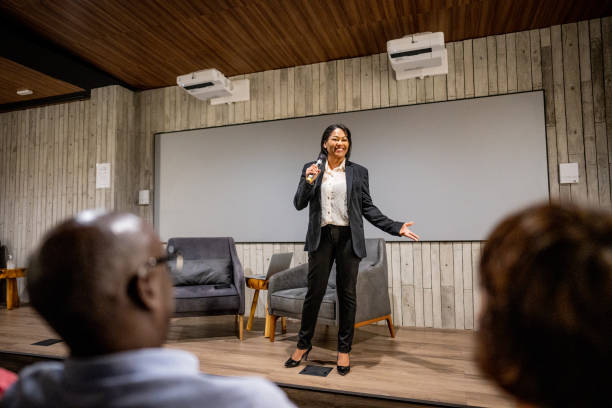 istock Mature woman talking with public on microphone in a seminar 1497998832