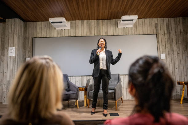istock Mature woman talking with public on microphone in a seminar 1497998839