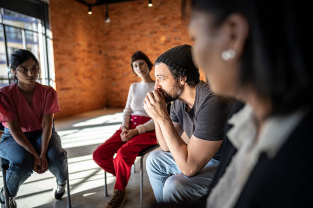 istock Mid adult man talking during a therapy group 1497999969