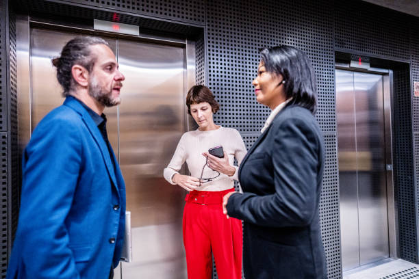 istock Coworkers talking waiting the elevator at office 1498001862