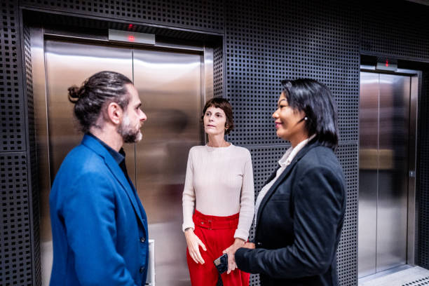 istock Coworkers talking waiting the elevator at office 1498001863