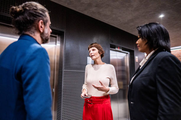 istock Coworkers talking waiting the elevator at office 1498001866