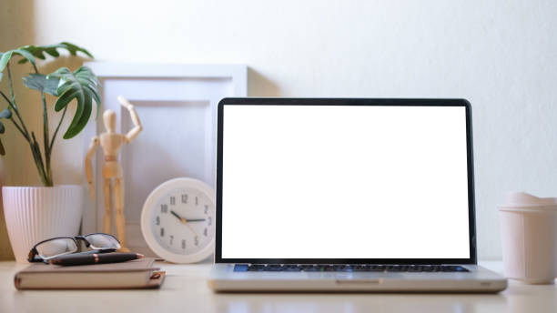 istock Modern workplace with laptop computer, coffee cup, potted plant and picture frame. Blank screen for your advertise text. 1498002225