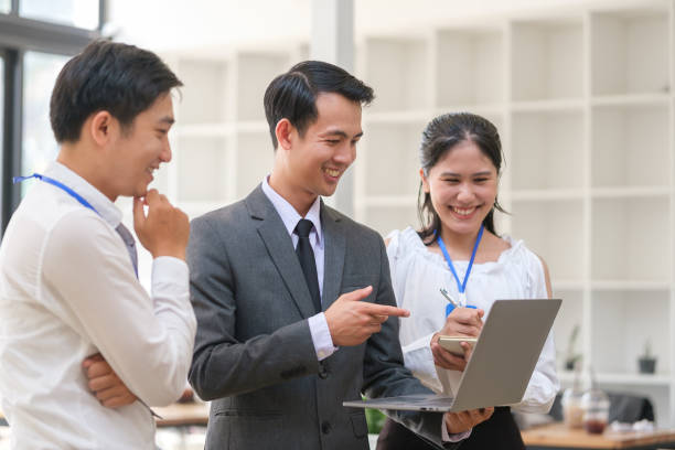 istock Happy friendly business team using laptop, working together on a new project at modern office. 1498002317