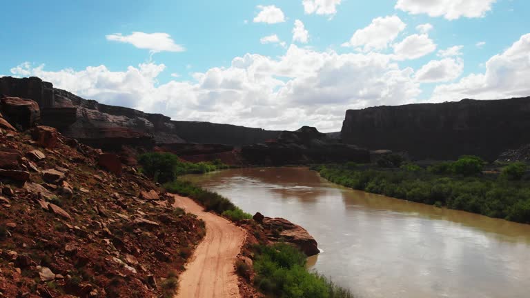 From a bird's-eye view, Mineral Canyon near Dead Horse Point, Utah, enchants with its rugged charm. The serpentine Green River carves its path through the canyon, while the distant silhouette of Canyonlands National Park beckons exploration.