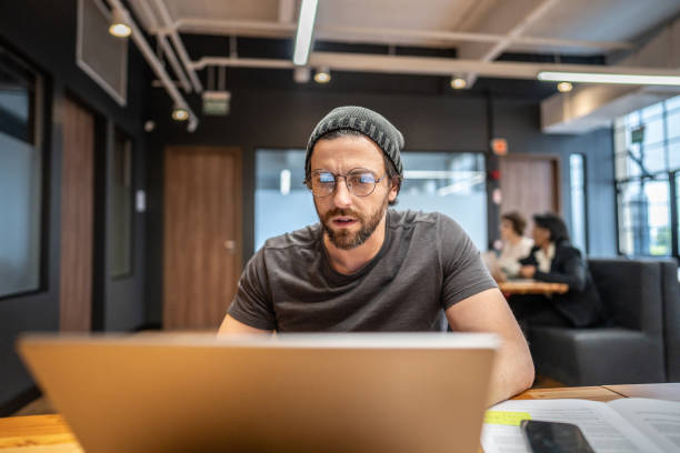 Mid adult businessman working using laptop at office