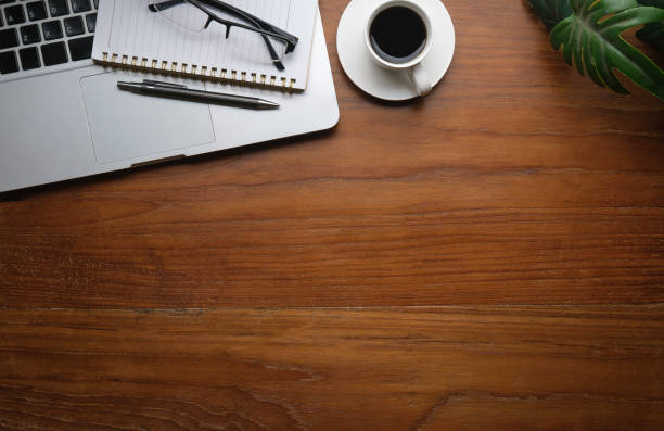 istock Flat lay laptop, cup of coffee and notebook on wooden table. Top view with copy space. 1498003604