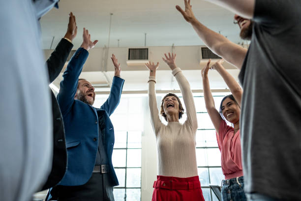 istock Coworkers celebrating with arms raised at office 1498003783