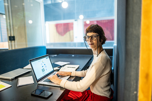 Portrait of a mature businesswoman working using laptop at office