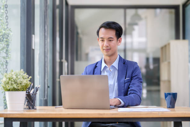 istock Handsome male financial advisor typing on laptop, reading message email or chatting with clients online, 1498006420